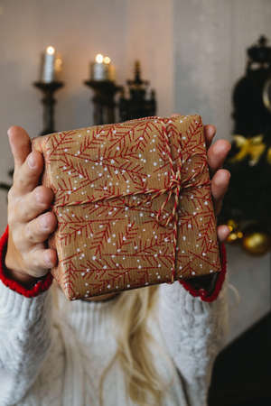 Girl in White Knitted Sweater Holding Christmas Gift Box Close Up Happy Winter Festive Conceptの写真素材