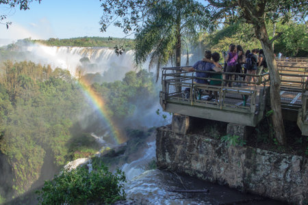 Iguassu National Park, Argentina - September 19, 2009  Tourists admiring the mighty Iguassu waterfalls, and a rainbow, in Iguassu National Park on the border of Argentina and Brazil  Argentinian sideのeditorial素材