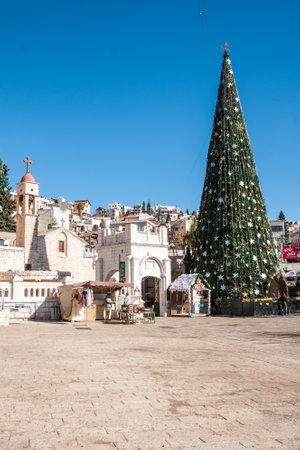 NAZARETH, ISRAEL - DEC 23, 2013  Local and visitors in front of a Christmas tree with the Nativity Scene, Near the Greek Orthodox Church of the Annunciation, in Nazareth, Israelのeditorial素材
