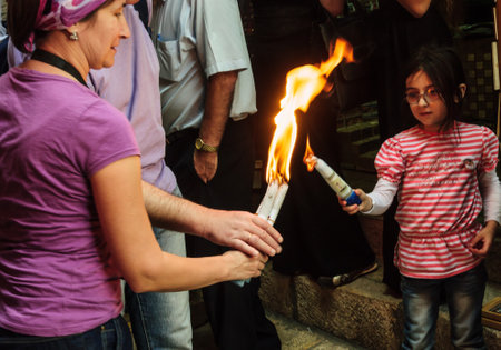 JERUSALEM - APRIL 19, 2014  The holy fire from the holy fire ceremony the Church of the Holy Sepulcher shared between pilgrims along the Via Dolorosa Street, on Holy Saturday, in Jerusalem, Israelのeditorial素材