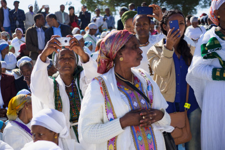 JERUSALEM - NOV 20, 2014: Ethiopian Jewish women mix old tradition of prays, with modern documentation devices, at the Sigd, in Jerusalem, Israel. The Sigd is an annual holiday of the Ethiopian Jewsのeditorial素材