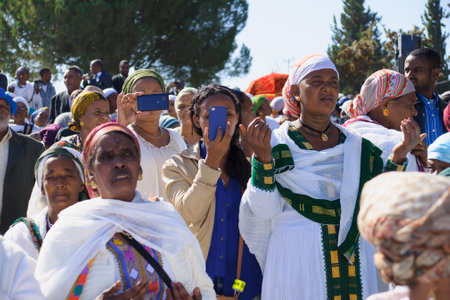 JERUSALEM - NOV 20, 2014: Ethiopian Jewish women mix old tradition of prays, with modern documentation devices, at the Sigd, in Jerusalem, Israel. The Sigd is an annual holiday of the Ethiopian Jewsのeditorial素材