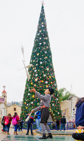 NAZARETH, ISRAEL - December 19, 2014: Jugglers, local and visitors, and a Christmas tree, in the square of the Greek Orthodox Church of Annunciation, in Nazareth, Israelのeditorial素材
