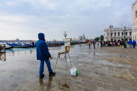VENICE, ITALY - FEB 03, 2015: Scene of the flooded Molo San Marco, with local artist, local and tourists, in Venice, Veneto, Italyのeditorial素材