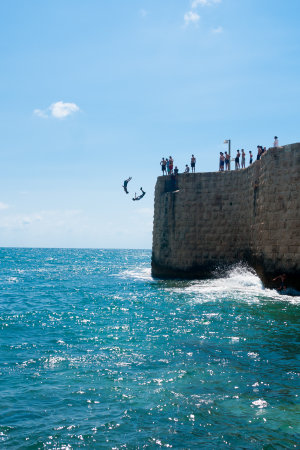 ACRE, ISRAEL - JUNE 27, 2009: Young men jumps to the sea from the top of the ancient walls of Acre, Israel. Acre is one of the oldest continuously inhabited sites in the world.のeditorial素材