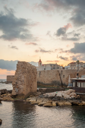 ACRE ISRAEL  MAY 04 2015: Sunset scene of the old city walls St. John the Baptist church and local fishermen in the old city of Acre Israelのeditorial素材
