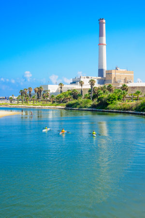 TEL AVIV ISRAEL  JUNE 12 2015: Scene of rowers in the Yarkon stream fishermen and the Reading Power Station in TelAviv Israelのeditorial素材