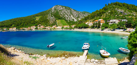 TRSTENIK, CROATIA - JUNE 25, 2015: Panoramic view of the bay and the village, with locals and tourists, in Trstenik, Croatiaのeditorial素材