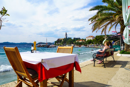 LOPUD, CROATIA - JUNE 27, 2015: Scene of the fishing port and the beach, with cafes, boats, locals and tourists, in the village Lopud, Lopud Island, one of the Elaphiti Islands, Croatiaのeditorial素材