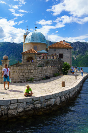 PERAST, MONTENEGRO - JUNE 28, 2015: Scene of Our Lady of the Rocks church, with local and tourists. On an artificial island in the Bay of Kotor, Montenegroのeditorial素材