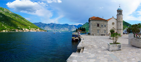 PERAST, MONTENEGRO - JUNE 28, 2015: Panoramic view of Our Lady of the Rocks church, and the town of Perast, with local and tourists. The Bay of Kotor, Montenegroのeditorial素材