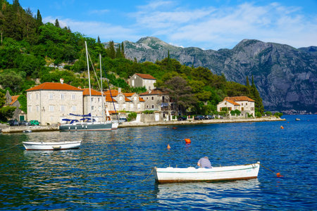 PERAST, MONTENEGRO - JUNE 28, 2015: Scene of the promenade, with cafes, old buildings, boats, locals and tourists, in Perast, Montenegroのeditorial素材