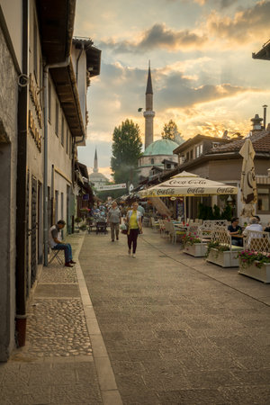 SARAJEVO, BIH - JULY 04, 2015: Typical street scene, with the Havadze Duraka Mosque, local businesses, locals and tourists, in Sarajevo, Bosnia and Herzegovinaのeditorial素材