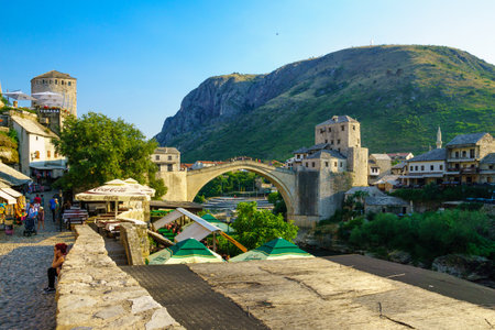 MOSTAR, BIH - JULY 05, 2015: Scene of the old city and the restored Old Bridge Stari Most, with locals and tourists, in Mostar, Bosnia and Herzegovinaのeditorial素材
