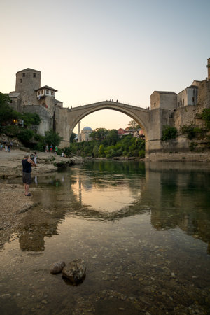 MOSTAR, BIH - JULY 05, 2015: The restored Old Bridge Stari Most on sunset, with locals and tourists, in Mostar, Bosnia and Herzegovinaのeditorial素材