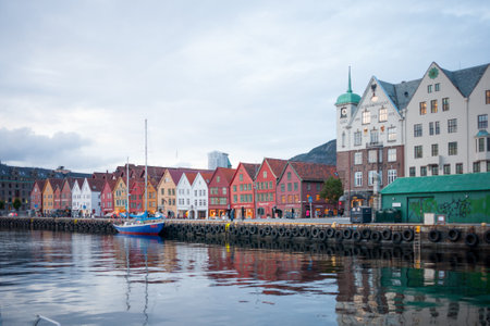 BERGEN, NORWAY - SEPTEMBER 21, 2010: Sunset scene of Bryggen, with locals and tourists, in Bergen, Norway. Bryggen, a UNESCO World Heritage Site, is famous for its old wooden buildings.のeditorial素材