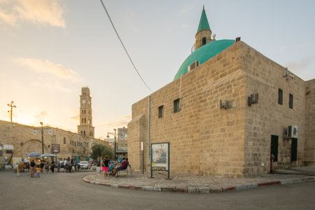 ACRE, ISRAEL - OCTOBER 01, 2015: Street scene with Sinan Basha Mosque alBahr Mosque, the clock tower, locals and visitors, in the old city of Acre, Israelのeditorial素材