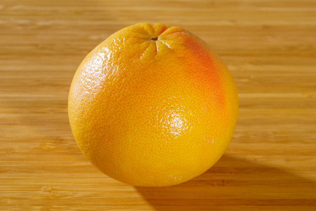 Red grapefruit on a wooden backgroundの写真素材