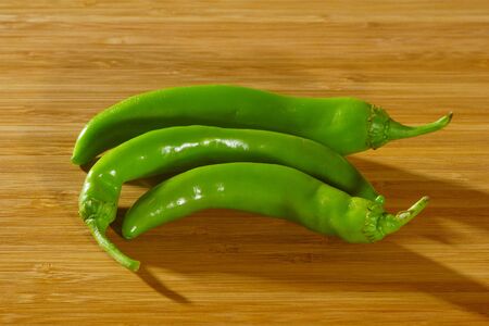 Green Chili Peppers on a wooden backgroundの写真素材
