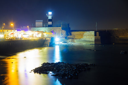 ACRE, ISRAEL - OCTOBER 18, 2015: Night scene of a Templar Fortress remains, lighthouse, restaurants, visitors and Haifa bay, in the old city of Acre, Israelのeditorial素材
