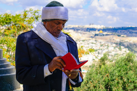 JERUSALEM, ISRAEL - NOVEMBER 11, 2015: An Ethiopian Jewish man pray at the Sigd, with the old city in the background, in Jerusalem, Israel. The Sigd is an annual holiday of the Ethiopian Jewryのeditorial素材