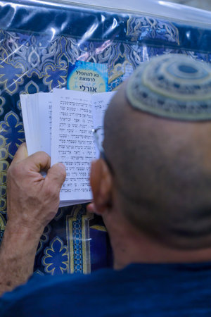 NETIVOT, ISRAEL - JANUARY 13, 2016: Jewish man prays at the Rabbi Israel Abuhaseira Baba Sali tomb, as part of the annual hillula of his memory. In Netivot, Israelのeditorial素材
