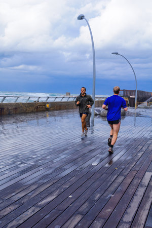 TEL-AVIV - JANUARY 25, 2016: Winter scene, in the Tel-Aviv Port compound, with joggers, Israel. The port compound was restored as a dining and commercial areaのeditorial素材