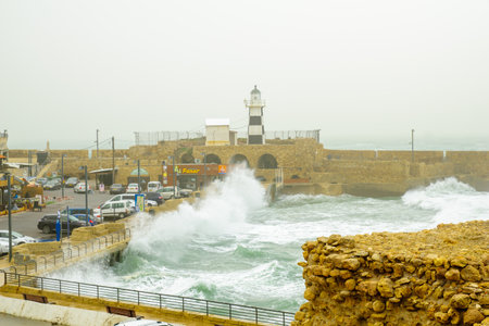 ACRE, ISRAEL - JANUARY 18, 2016: Stormy winter day scene of a Templar Fortress remains, lighthouse, restaurants, visitors and Haifa bay, in the old city of Acre, Israelのeditorial素材
