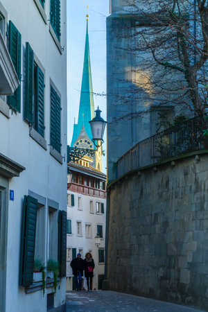 ZURICH, SWITZERLAND - DECEMBER 25, 2015: An alley in the old town with the tower of Fraumunster Church, locals and visitors. In Zurich, Switzerlandのeditorial素材
