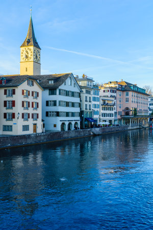 ZURICH, SWITZERLAND - DECEMBER 25, 2015: View of the Old Town Altstadt and the Limmat River, with the clock tower of St. Peter Churches, locals and visitors. In Zurich, Switzerlandのeditorial素材