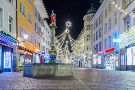 WINTERTHUR, SWITZERLAND - DECEMBER 26, 2015: Night scene of Marktgasse Street, with the Justitia Fountain, Christmas decorations, locals and visitors in Winterthur, Switzerlandのeditorial素材