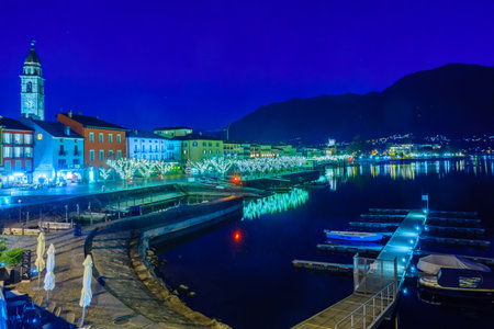 ASCONA, SWITZERLAND - DECEMBER 28, 2015: Night scene of the lake promenade Piazza Mota, with Christmas decoration, locals and visitors, in Ascona, Ticino, Switzerlandのeditorial素材