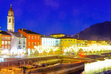 ASCONA, SWITZERLAND - DECEMBER 28, 2015: Night scene of the lake promenade Piazza Mota, with Christmas decoration, locals and visitors, in Ascona, Ticino, Switzerlandのeditorial素材