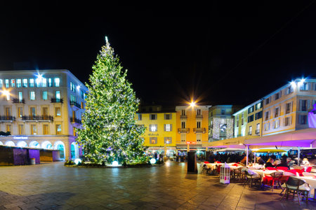 LUGANO, SWITZERLAND - DECEMBER 29, 2015: Evening scene in Piazza della Riforma Reform square, with Christmas tree and decorations, locals and visitors, in Lugano, Ticino, Switzerlandのeditorial素材