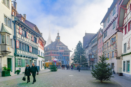 STEIN AM RHEIN, SWITZERLAND - DECEMBER 26, 2015: View of buildings with painted facades, with Oriel windows, Christmas trees, locals and visitors, in Stein am Rhein, Switzerlandのeditorial素材