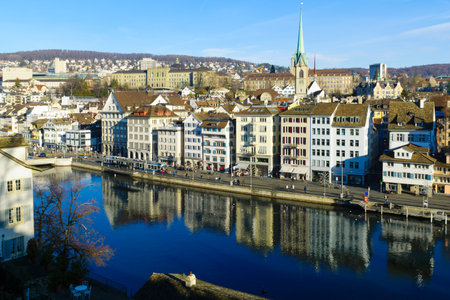 ZURICH, SWITZERLAND - DECEMBER 27, 2015: View of the east bank of the Limmat River, with the Predigerkirche church, locals and visitors. In Zurich, Switzerlandのeditorial素材
