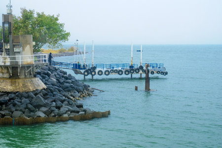 EIN GEV, ISRAEL - JANUARY 19, 2016: A pier and a fisherman in the Sea of Galilee, in kibbutz Ein Gev, Northern Israelのeditorial素材