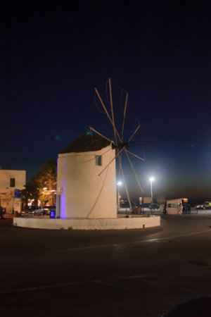 PAROS, GREECE - SEPTEMBER 30, 2011: Night scene with a windmill, locals and visitors, in Paros, Paros Island, Greeceのeditorial素材