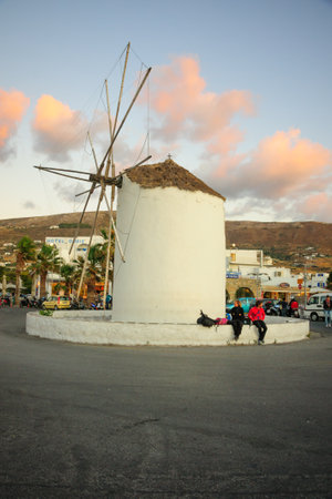 PAROS, GREECE - OCTOBER 01, 2011: Sunset scene with a windmill, locals and visitors, in Paros, Paros Island, Greeceのeditorial素材