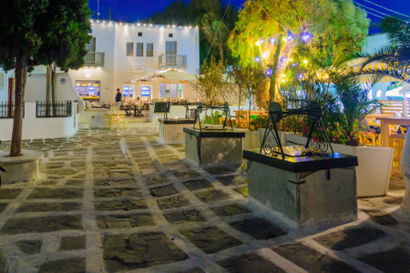 MYKONOS, GREECE - OCTOBER 02, 2011: Evening scene of the Tria Pigadia three identical wells, with local businesses, locals and visitors, in Mykonos, Mykonos Island, Greeceのeditorial素材