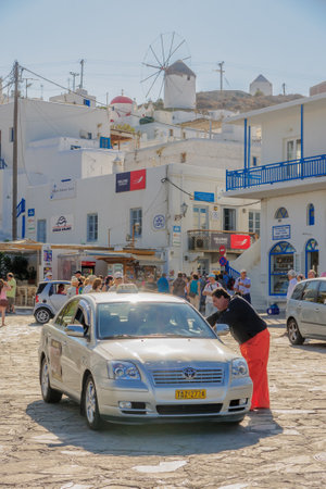 MYKONOS, GREECE - OCTOBER 04, 2011: Street scene, with local businesses, windmills, locals and visitors, in Mykonos, Mykonos Island, Greeceのeditorial素材
