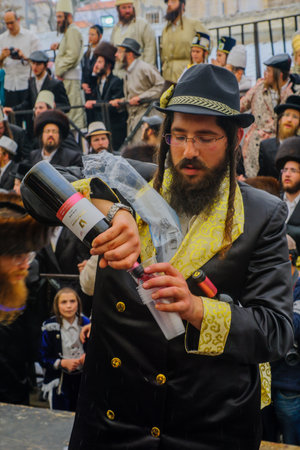JERUSALEM, ISRAEL - FEBRUARY 25, 2016: A man pour free wine to the crowd, as part of a celebration...