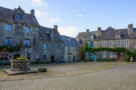 LOCRONAN, FRANCE - SEPTEMBER 29, 2012: Typical buildings, with locals and visitors, in Locronan, Brittany, Franceのeditorial素材