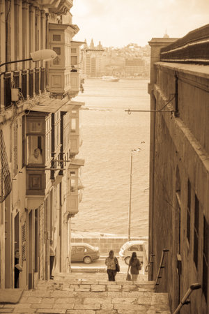 VALLETTA, MALTA - APRIL 13, 2012: Street scene with local businesses, locals and visitors, in Valletta, Maltaのeditorial素材