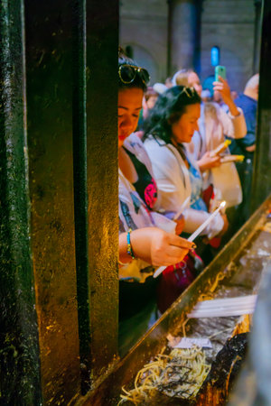 JERUSALEM, ISRAEL - APRIL 29, 2016: An Orthodox Good Friday scene in the church of the Holy Sepulcher, with women pilgrims lighting candles. The old city of Jerusalem, Israelのeditorial素材
