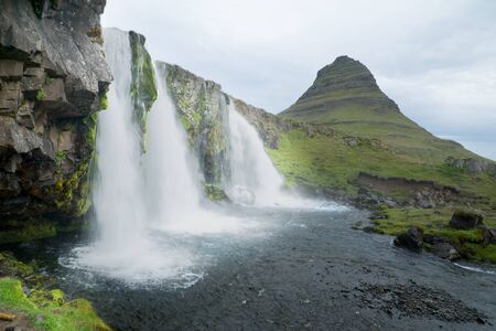 View of the Kirkjufell mountain (Church mountain), and the Kirkjufellsfoss waterfalls, in the Snaefellsnes peninsula, west Icelandの写真素材