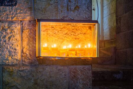 Traditional Menorah (Hanukkah Lamp) with olive oil candles, set for display near the entrance, in the Jewish quarter, Jerusalem Old City, Israelの写真素材