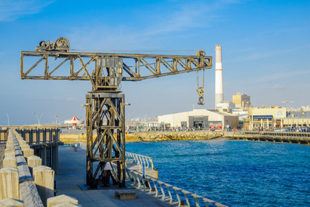 TEL-AVIV, ISRAEL - JANUARY 12, 2017: Scene with a restored crane, a carrousel, a commercial area, the Reading power station chimney, and visitors, in Tel-Aviv Port, Tel-Aviv, Israelのeditorial素材