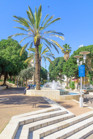 HAIFA, ISRAEL - FEBRUARY 20, 2017: Street scene in Hadar HaCarmel district, with a fountain, palm trees, locals and visitors, in Haifa, Israelのeditorial素材