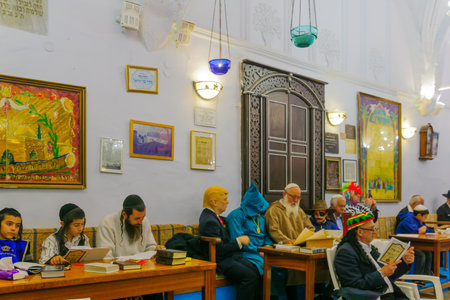 SAFED, ISRAEL - MAR 11, 2017: Traditional Purim (Jewish Holiday) in the old Abuhav synagogue with prayers, some in costumes, attend a reading of the megillah (Scroll of Esther). Safed (Tzfat), Israelのeditorial素材